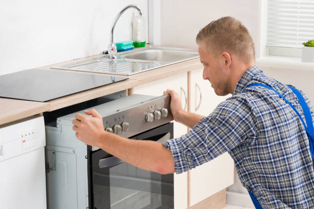 Wall oven technician working in a modern kitchen